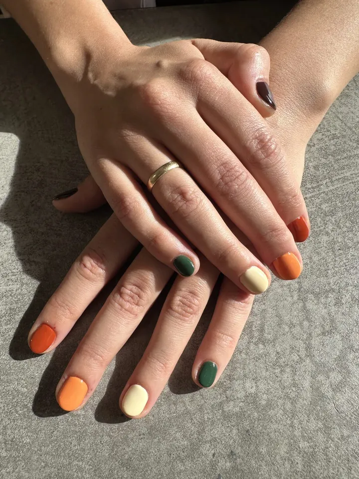 Uñas mate en naranja, verde oscuro y crema